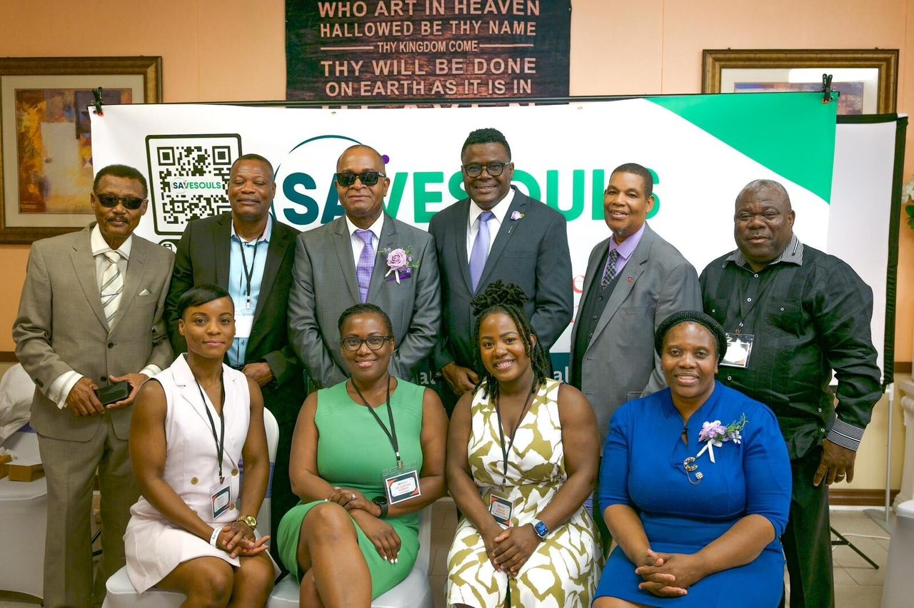 SaveSouls team members standing and seated in front of a SaveSouls banner.