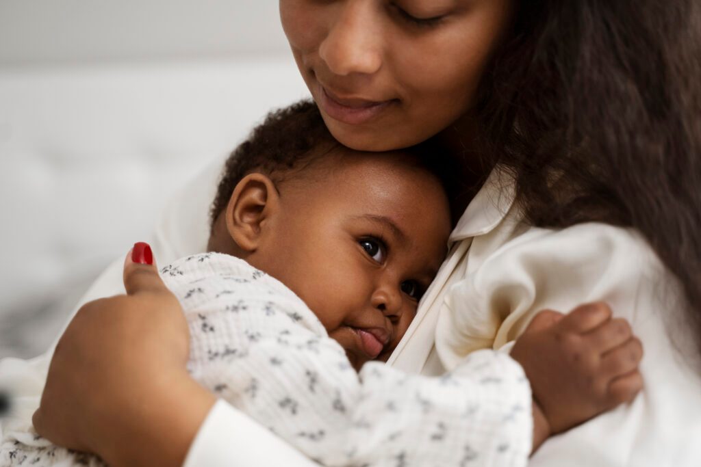 A woman holds a baby close.